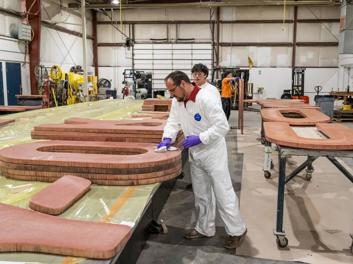 Janicki workers sanding letters
