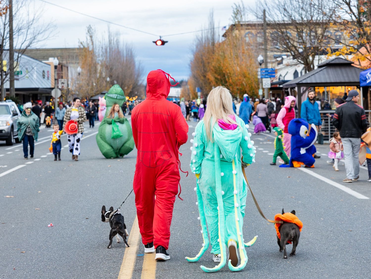People in costume walk down a closed street during a Halloween celebration in downtown Skagit Valley, Washington.